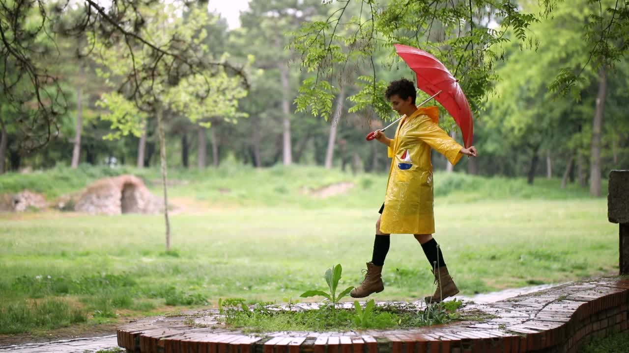 一个年轻女子在下雨天的公园里视频素材