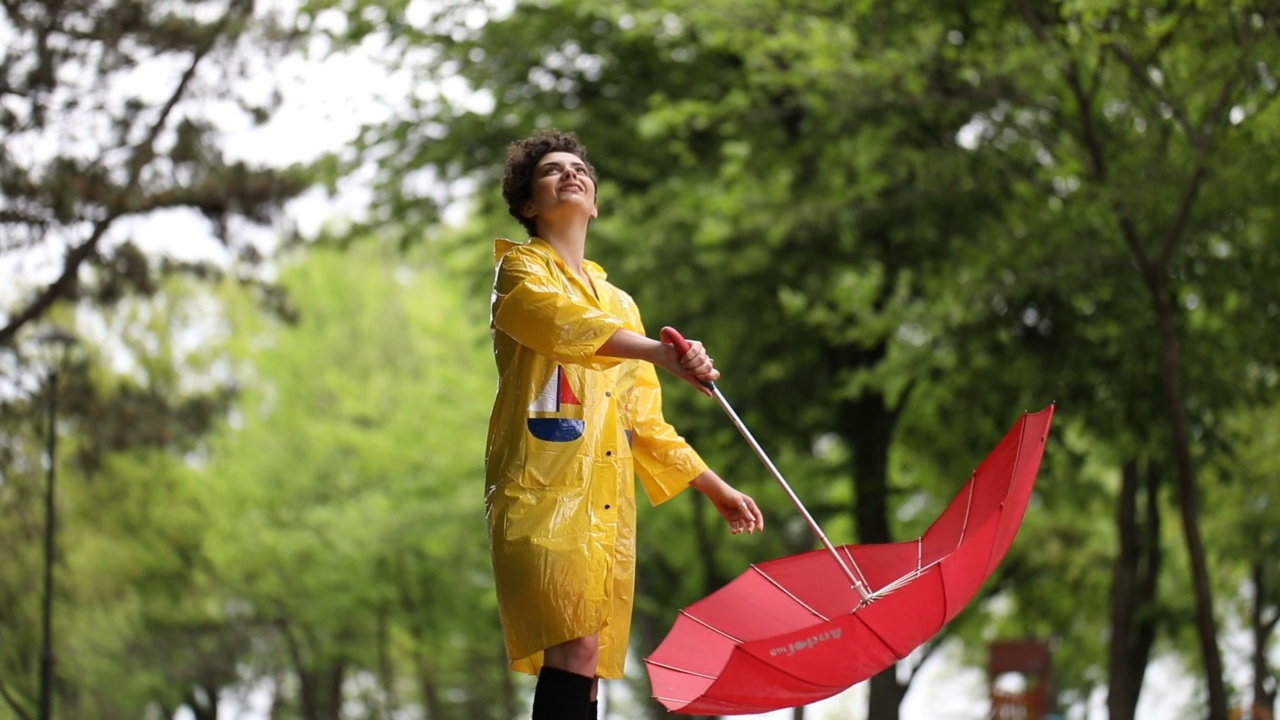 一个年轻女子在下雨天的公园里视频素材