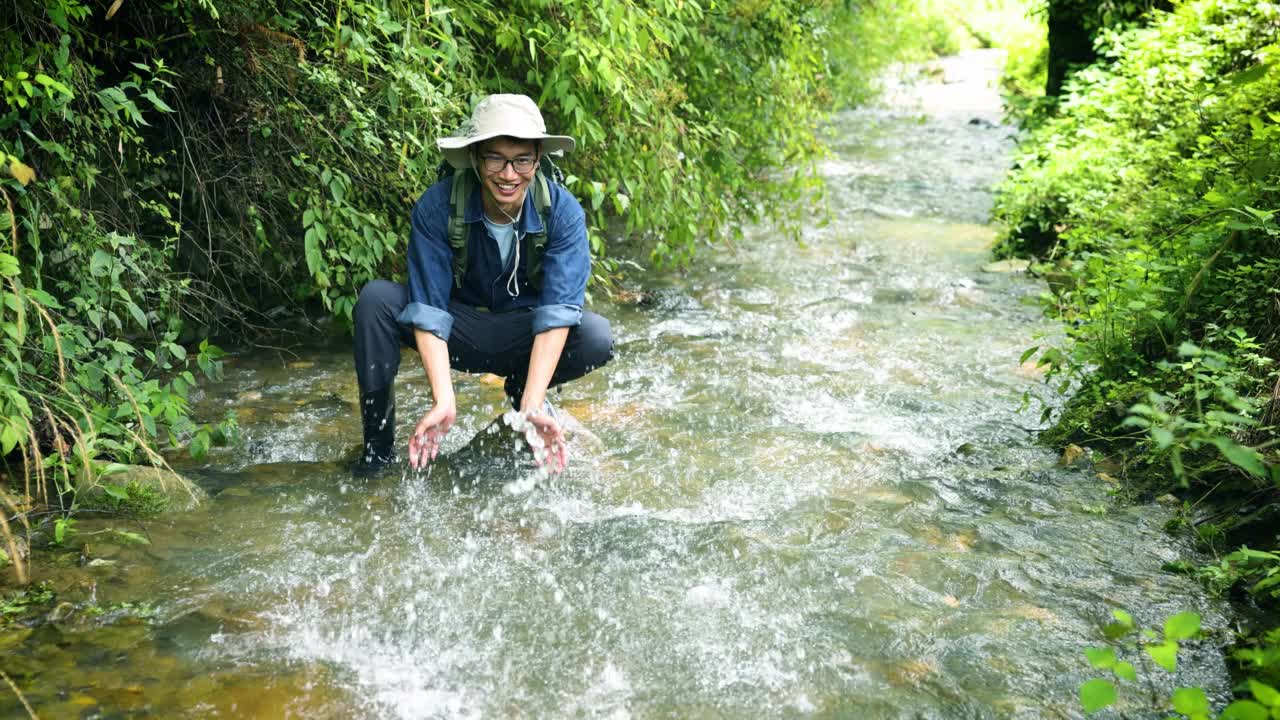 徒步旅行者在山涧中玩水视频素材