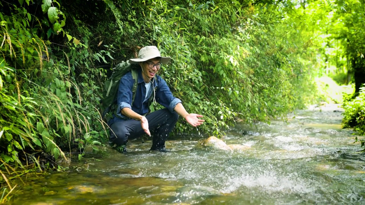 徒步旅行者在山涧中玩水视频素材