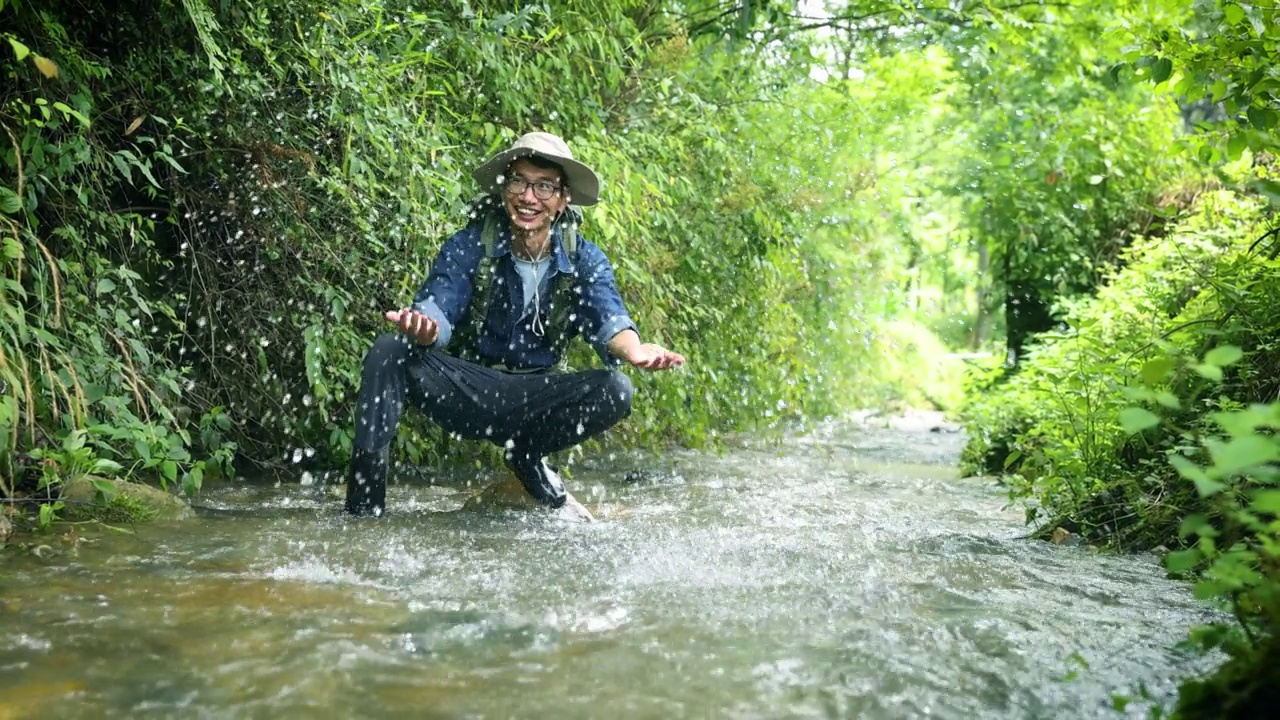 徒步旅行者在山涧中玩水视频素材