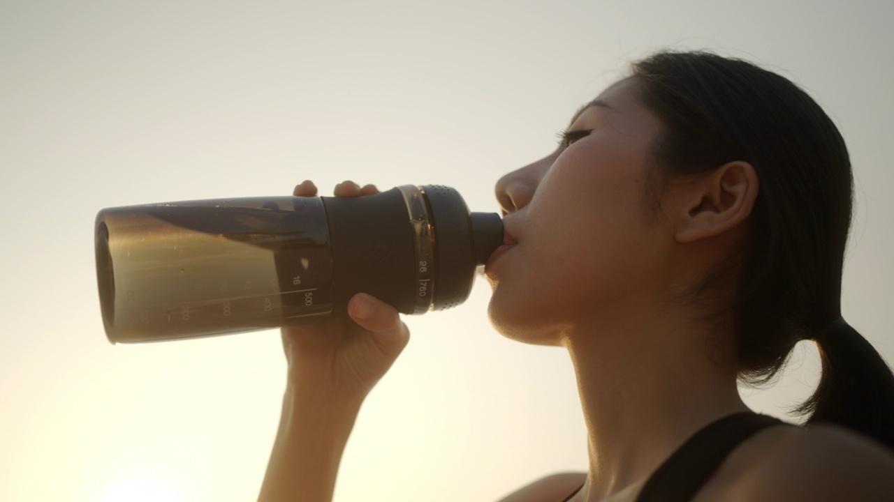 亚洲女运动员跑步后喝水视频素材