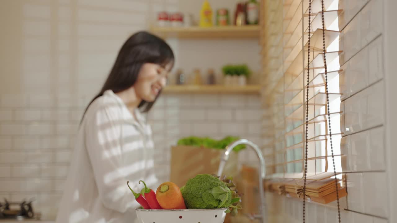 亚洲妇女在家厨房洗菜，健康饮食和健康理念，在家幸福视频素材