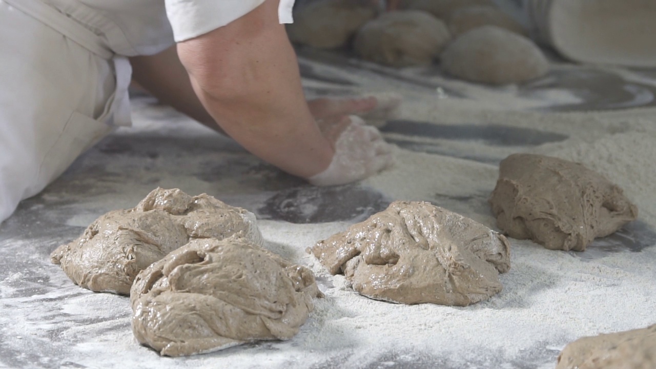 面包师在面包上揉面团。慢动作视频素材