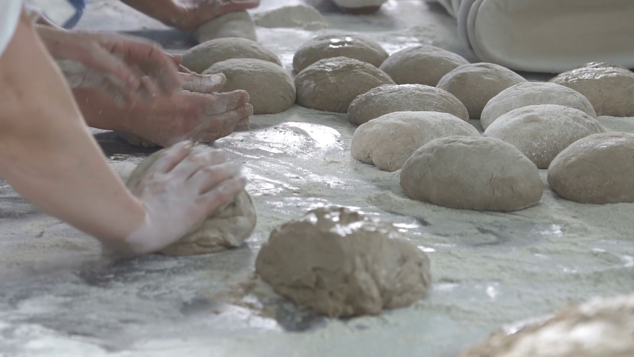 面包师在面包上揉面团。慢动作视频素材