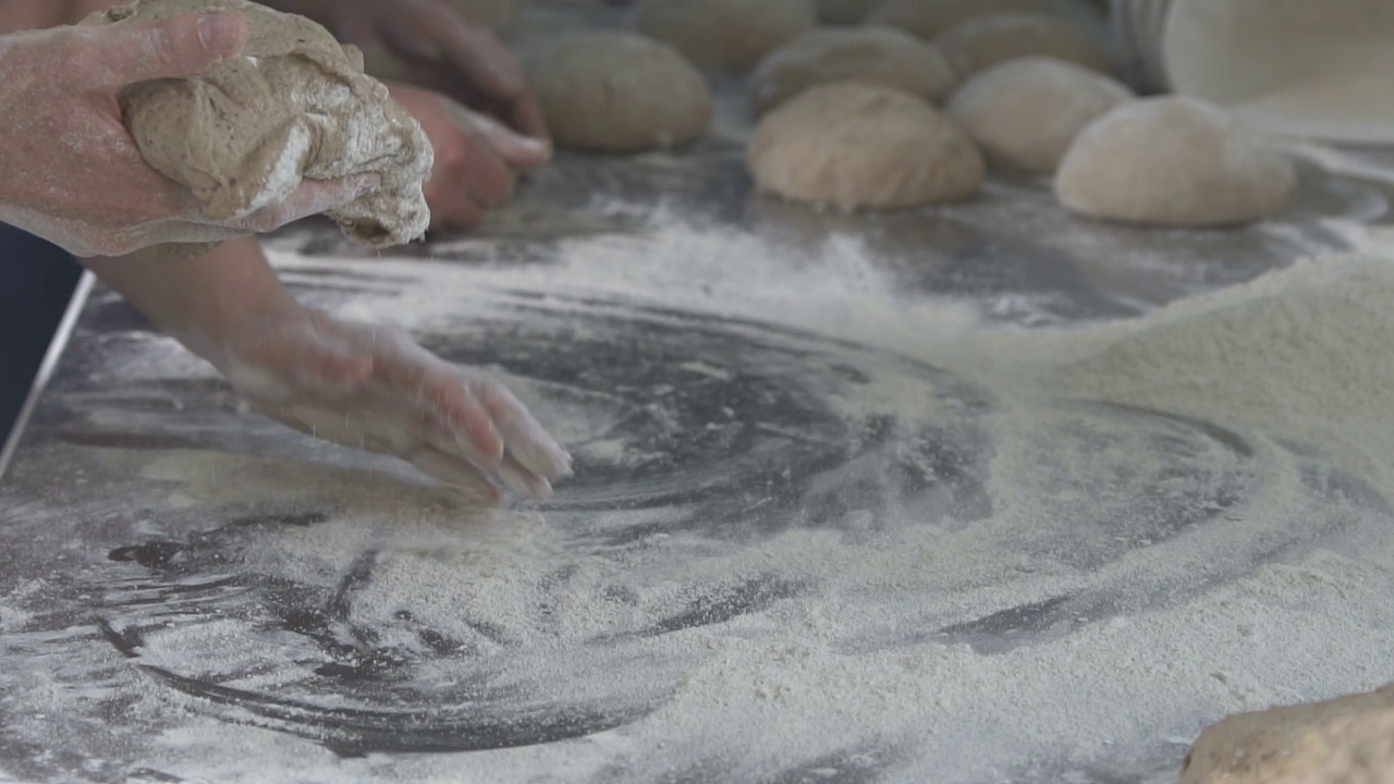 面包师在面包上揉面团。慢动作视频素材