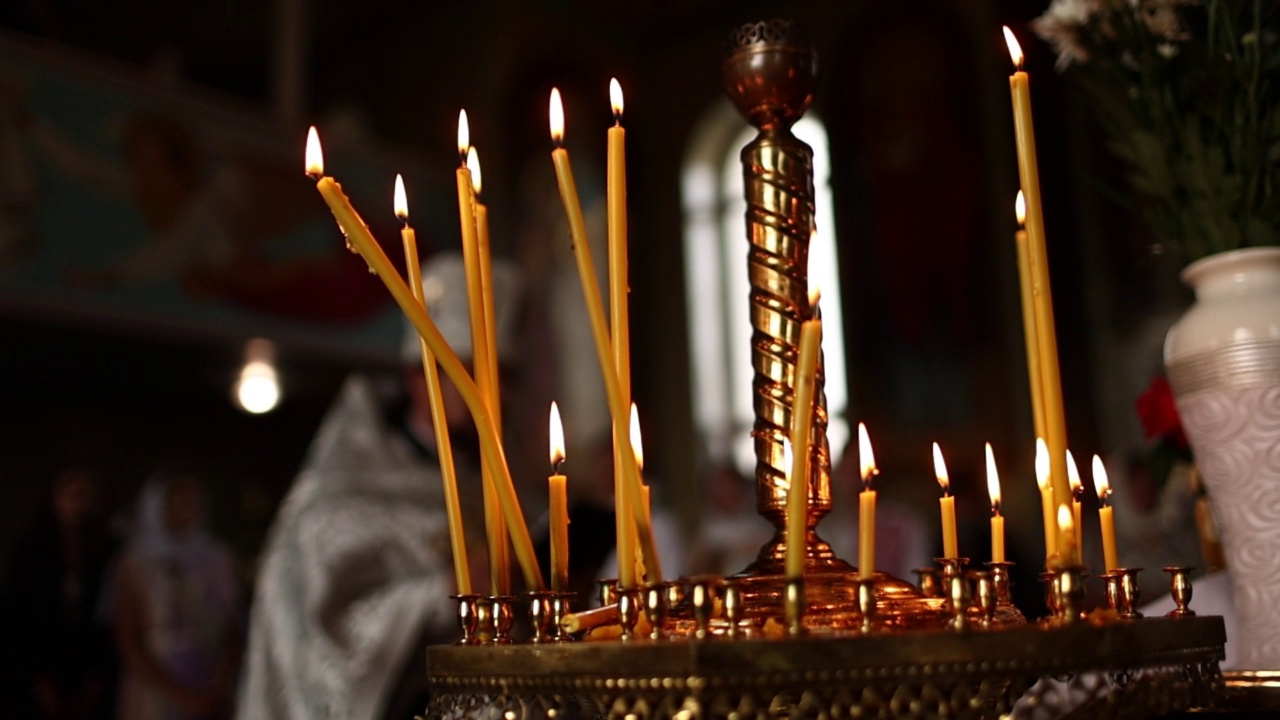 东正教教堂的最后一支蜡烛。教堂里的蜡烛在一个大的金色烛台上燃烧视频素材