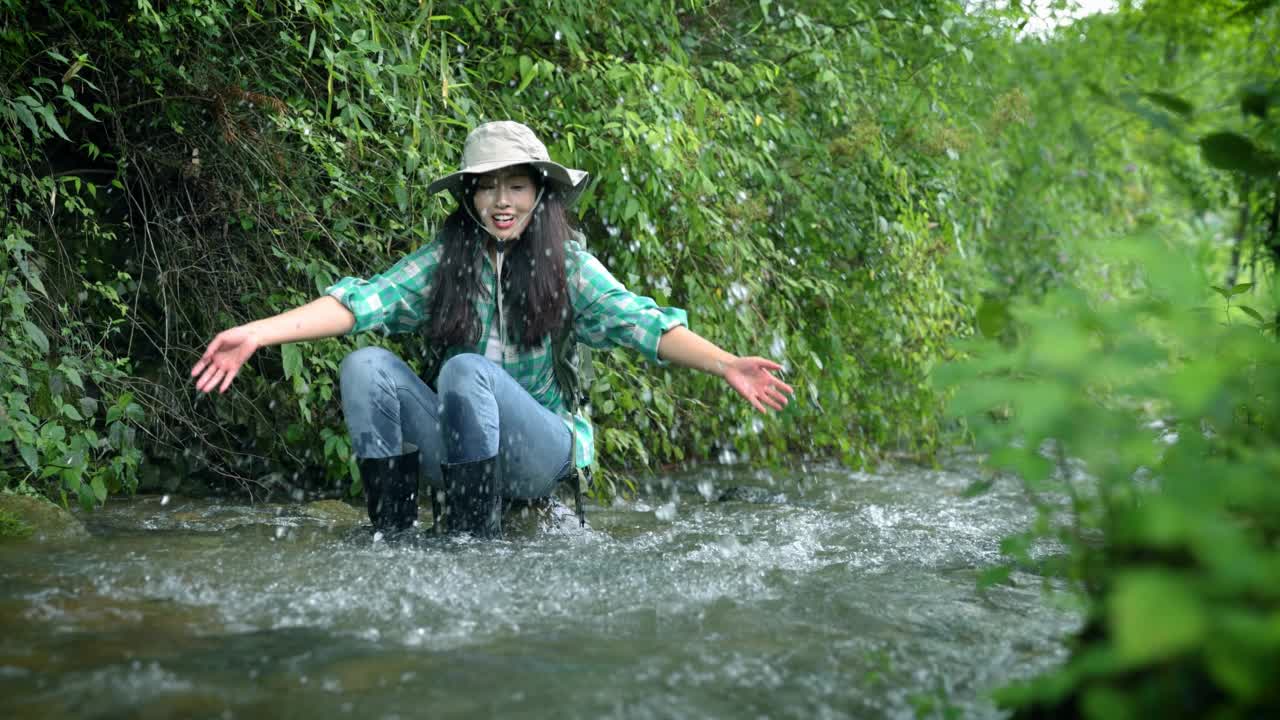 在山涧里玩水的女人视频素材