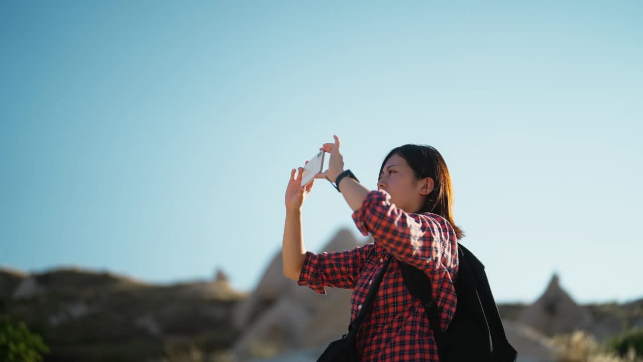 年轻的女游客在历史古城用手机拍照视频素材