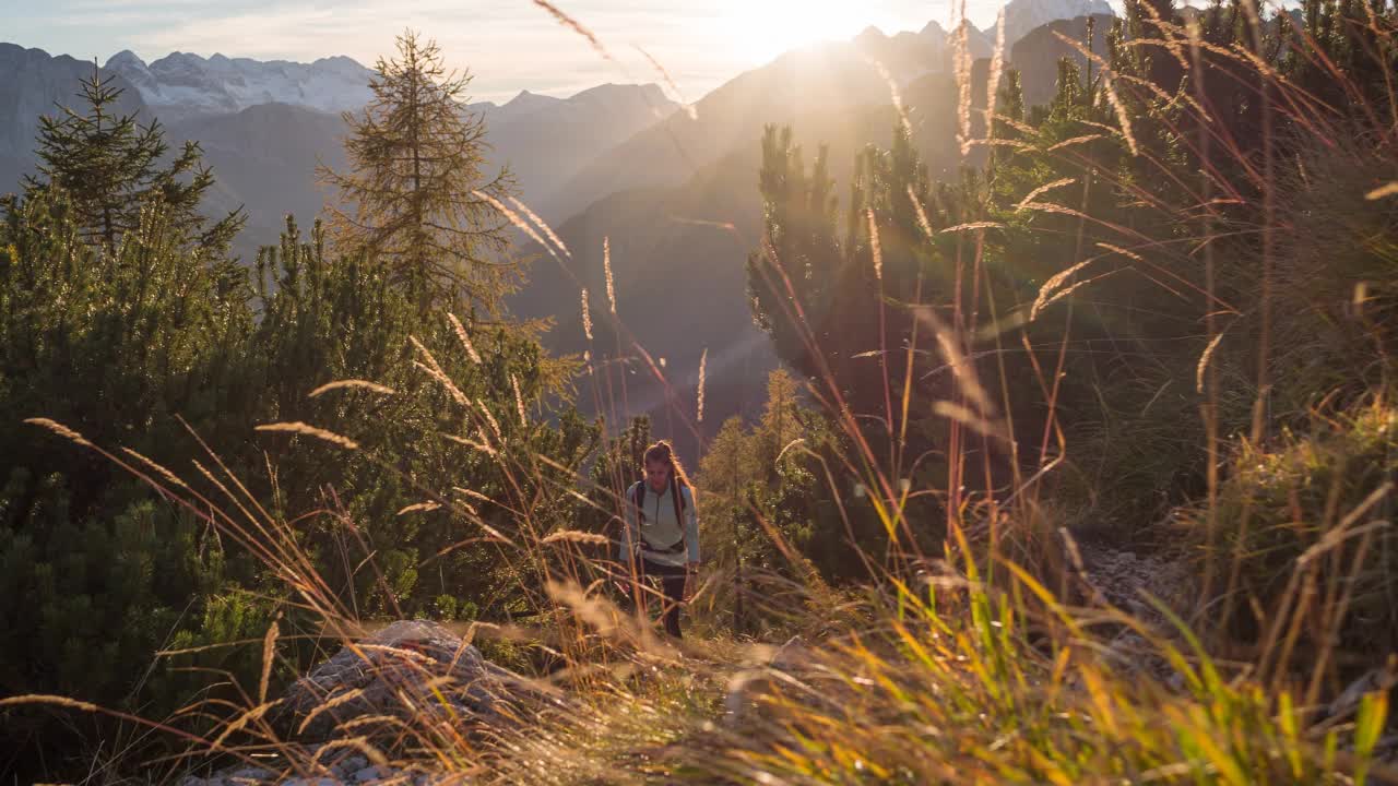 身体意识的女性保持健康的生活方式，走在山上地形，夕阳照明视频素材