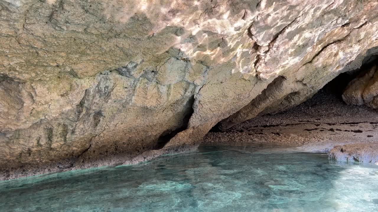 可怕的海岸岩石与光反射在神秘的海底洞穴洞穴。碧蓝清澈的海水和海岸峭壁。视频素材