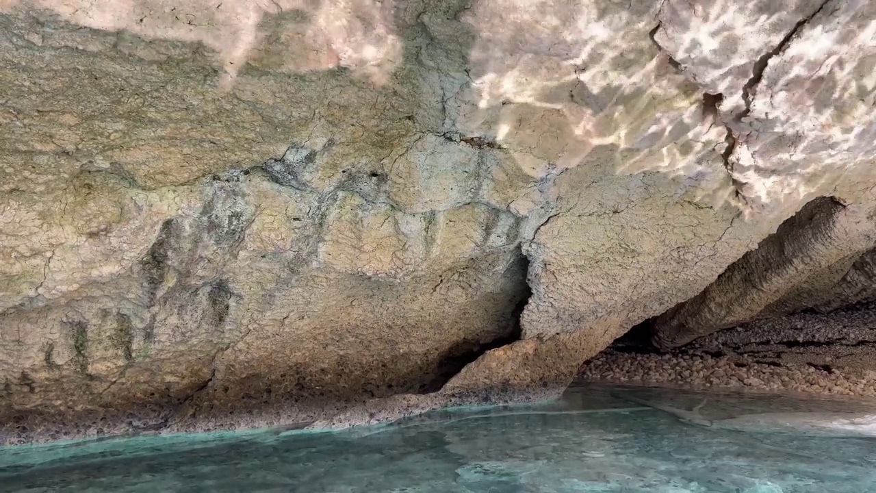 景区岩中有反光的神秘海洞石窟。碧蓝清澈的海水和海岸峭壁。视频素材