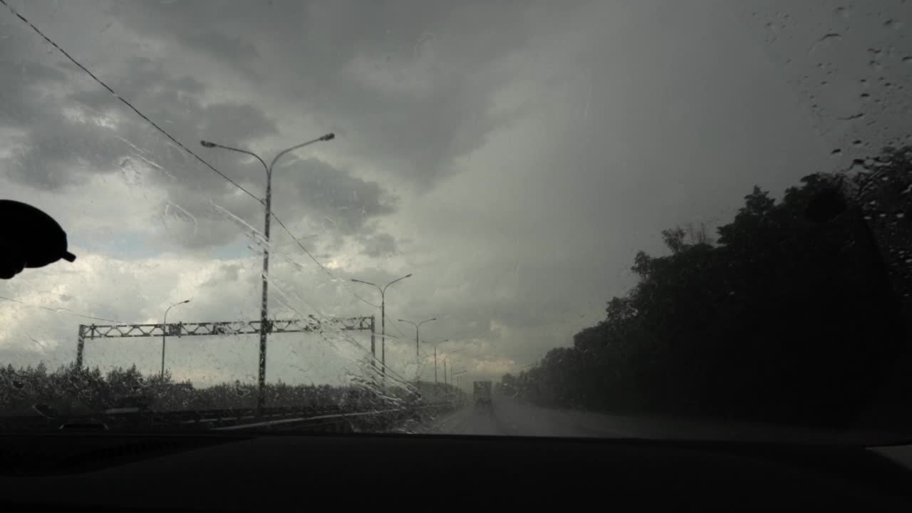 在大雨中行驶在高速公路上的汽车前窗。视频下载