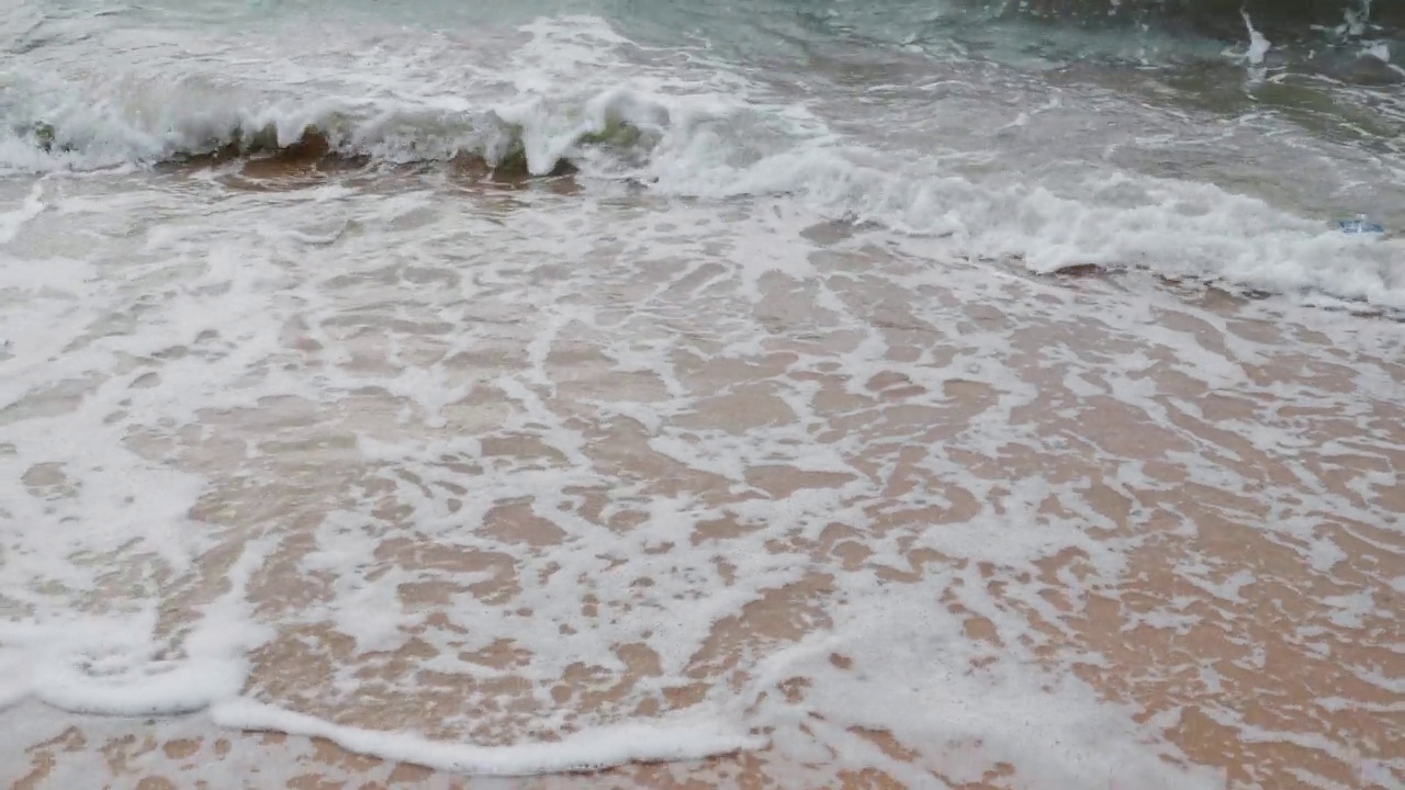 海滩上的慢动作泡沫波浪。沙滩上的浪花视频素材