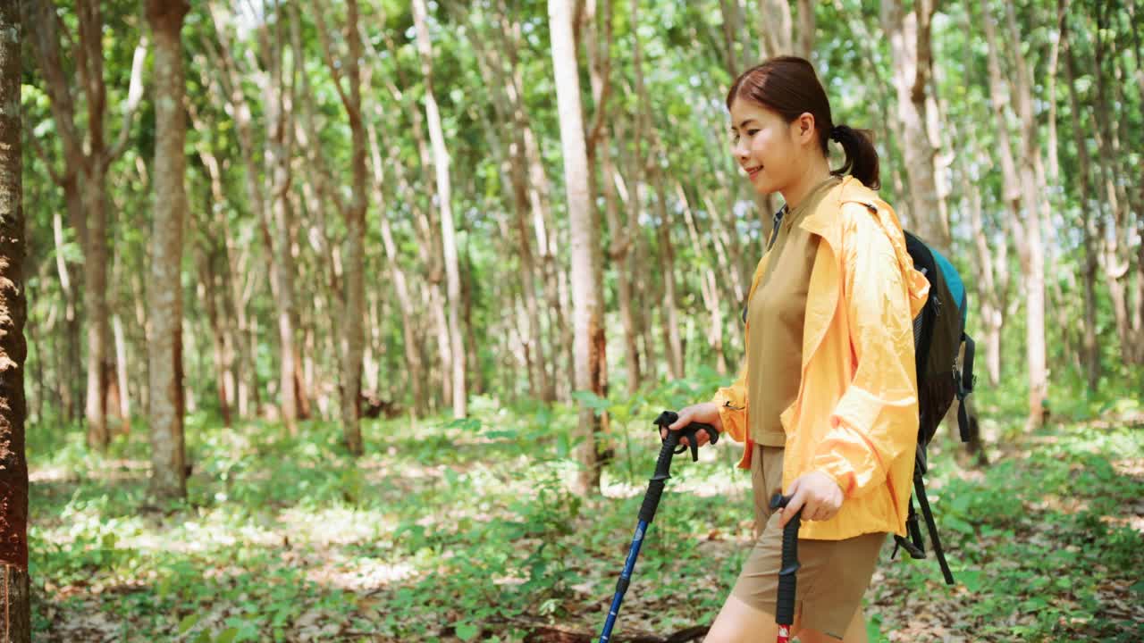 穿着黄色雨衣的背包女徒步旅行者视频素材