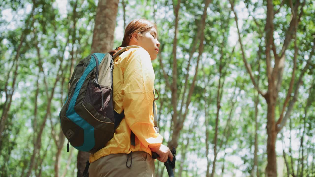 穿着黄色雨衣的背包女徒步旅行者视频素材