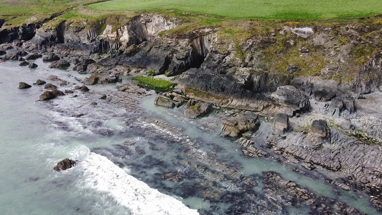 爱尔兰科克郡美丽的大西洋海岸。海浪拍打着海岸的岩石，海面起泡沫。视频素材