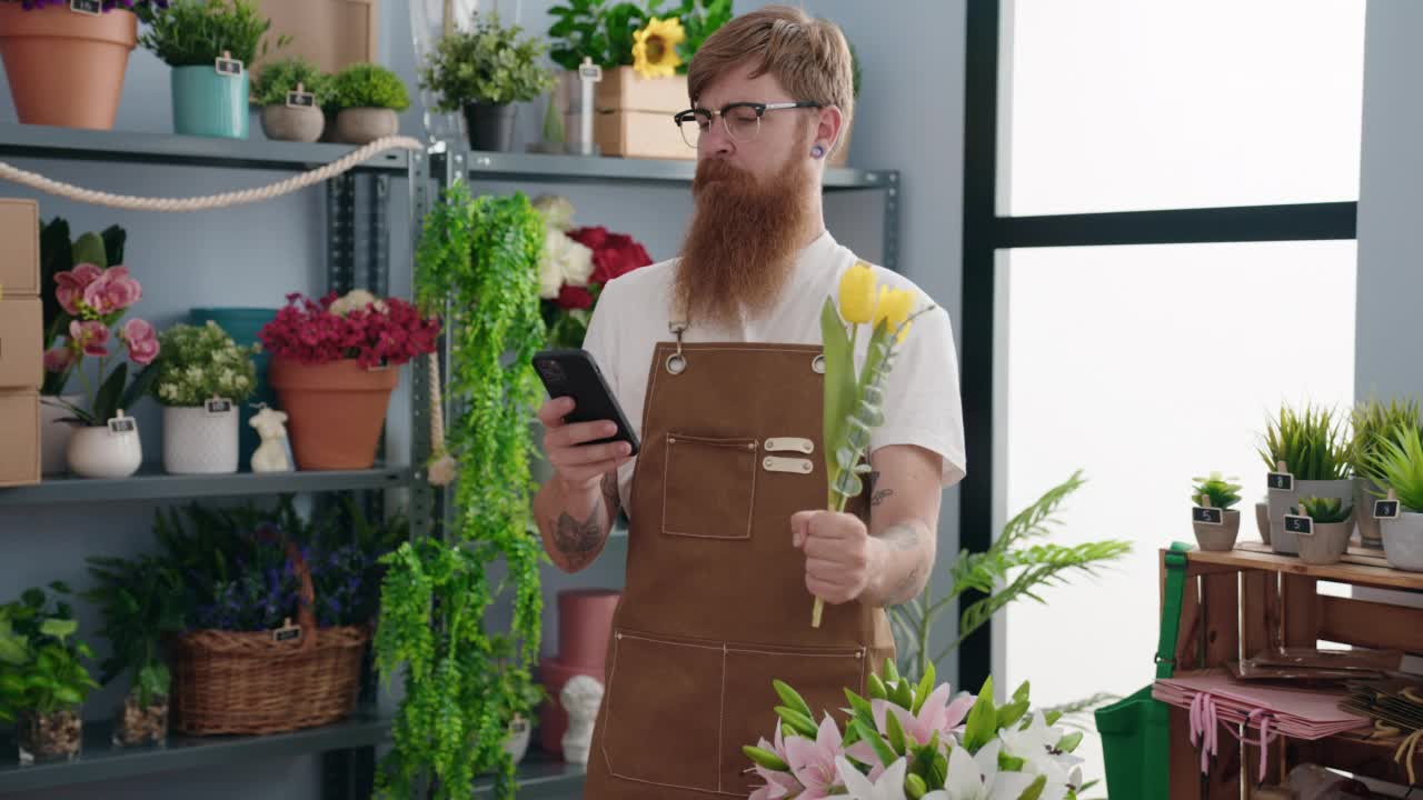 年轻的红发男子在花店用智能手机给花拍照视频素材