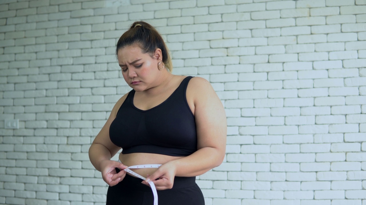 身材魁梧的女人用卷尺撑着肚子视频素材