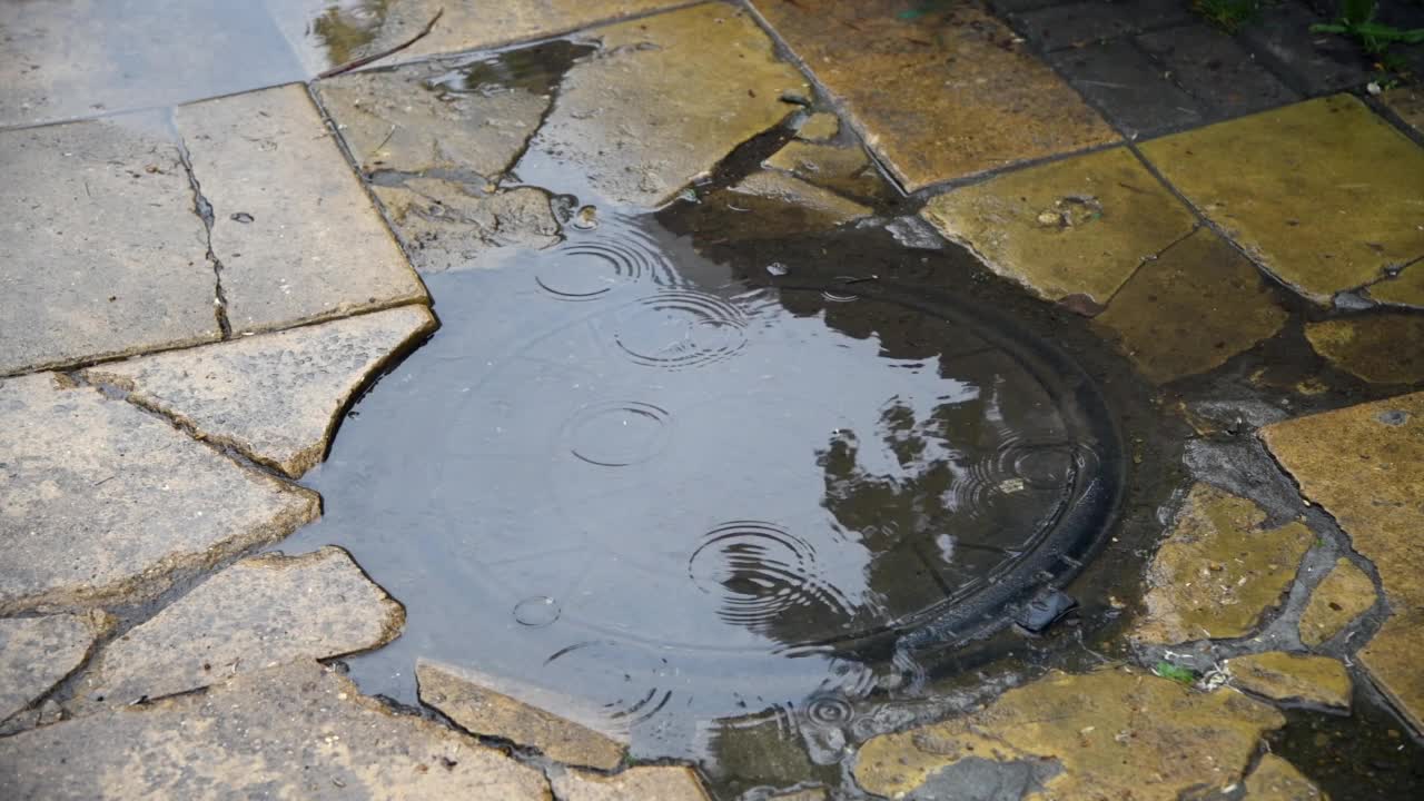 雨点落在下水道的水坑上视频素材