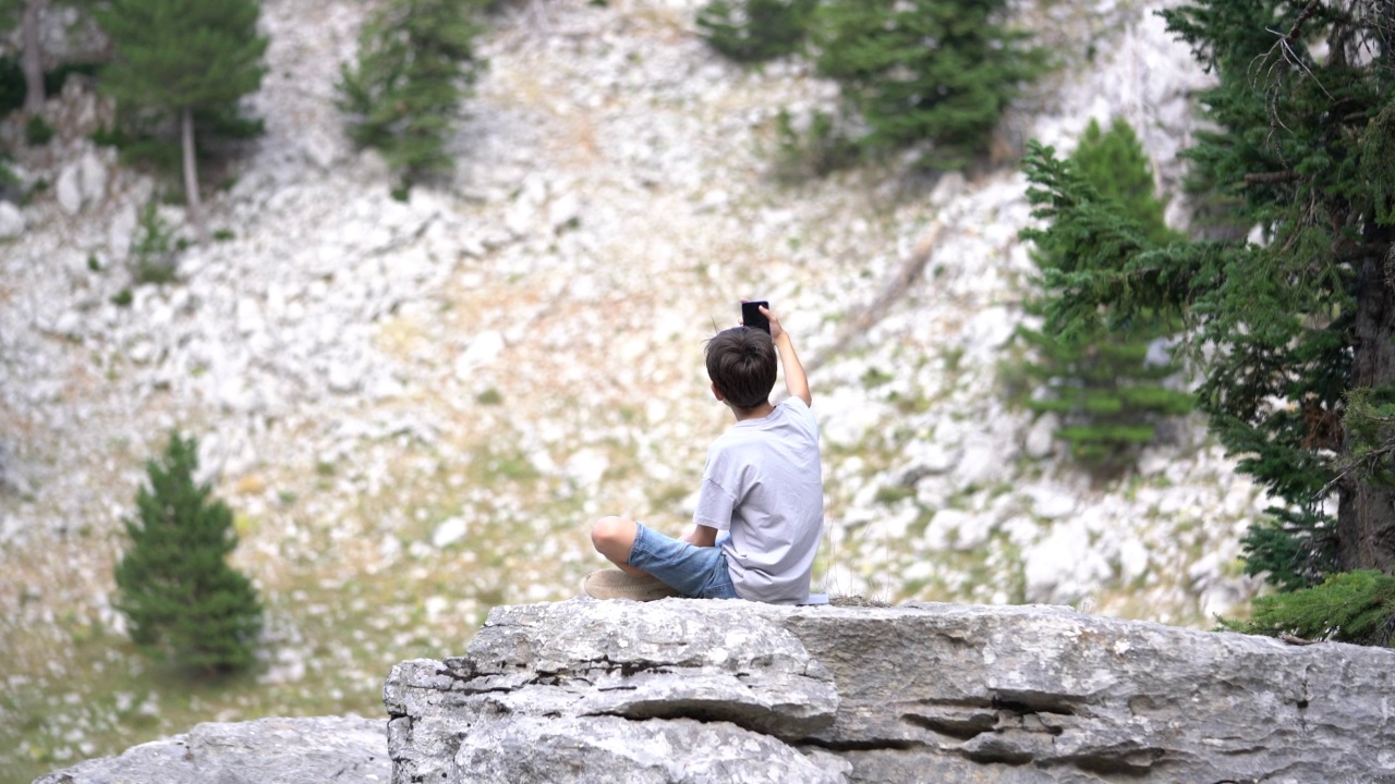 小男孩在山顶自拍。视频素材