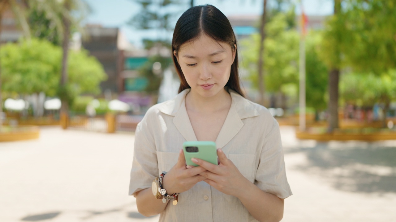 中国女子在公园用智能手机视频素材