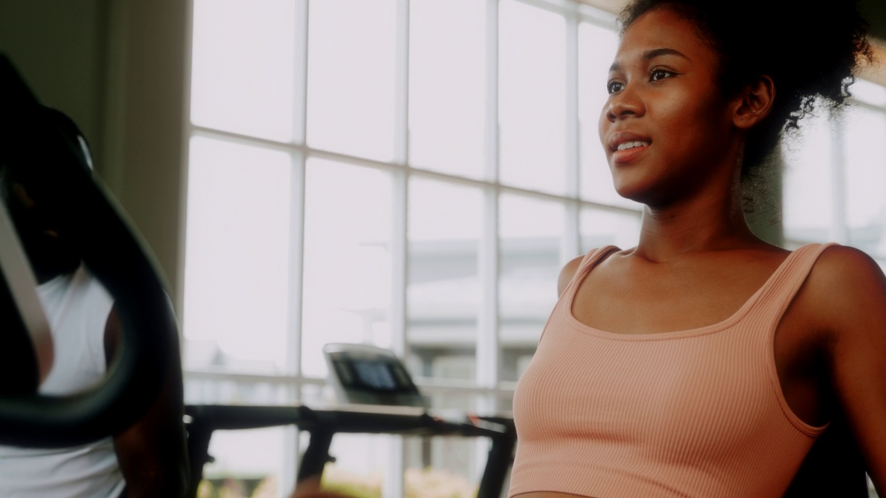 一位女士和她的朋友在健身房锻炼时聊天。视频素材