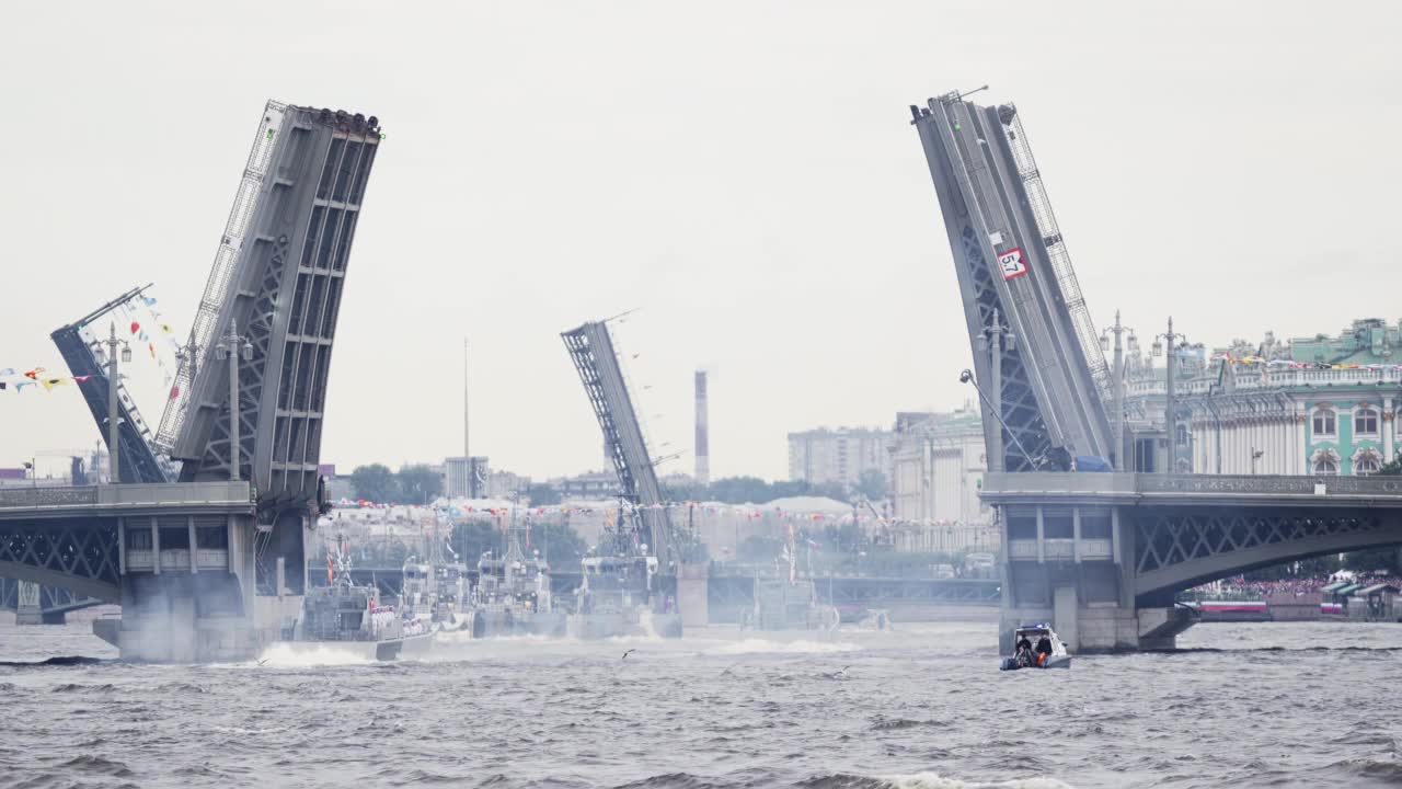 在晴朗的天气里，许多军舰在露天的桥梁下沿着涅瓦河进行海军日庆祝活动的彩排视频素材