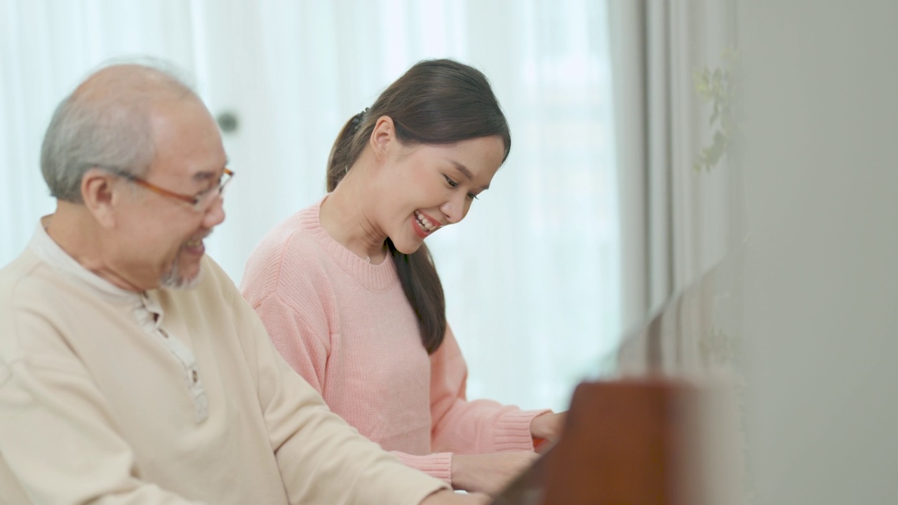 老人带着女儿在度假屋弹钢琴放松。视频素材