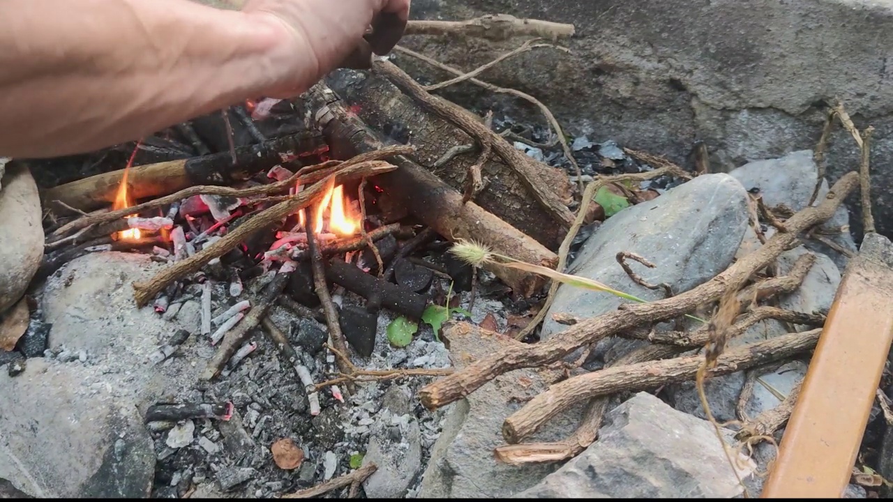 热煤的发光背景。灼热的木炭和树枝在烧烤烧烤坑与火焰背景纹理。视频素材