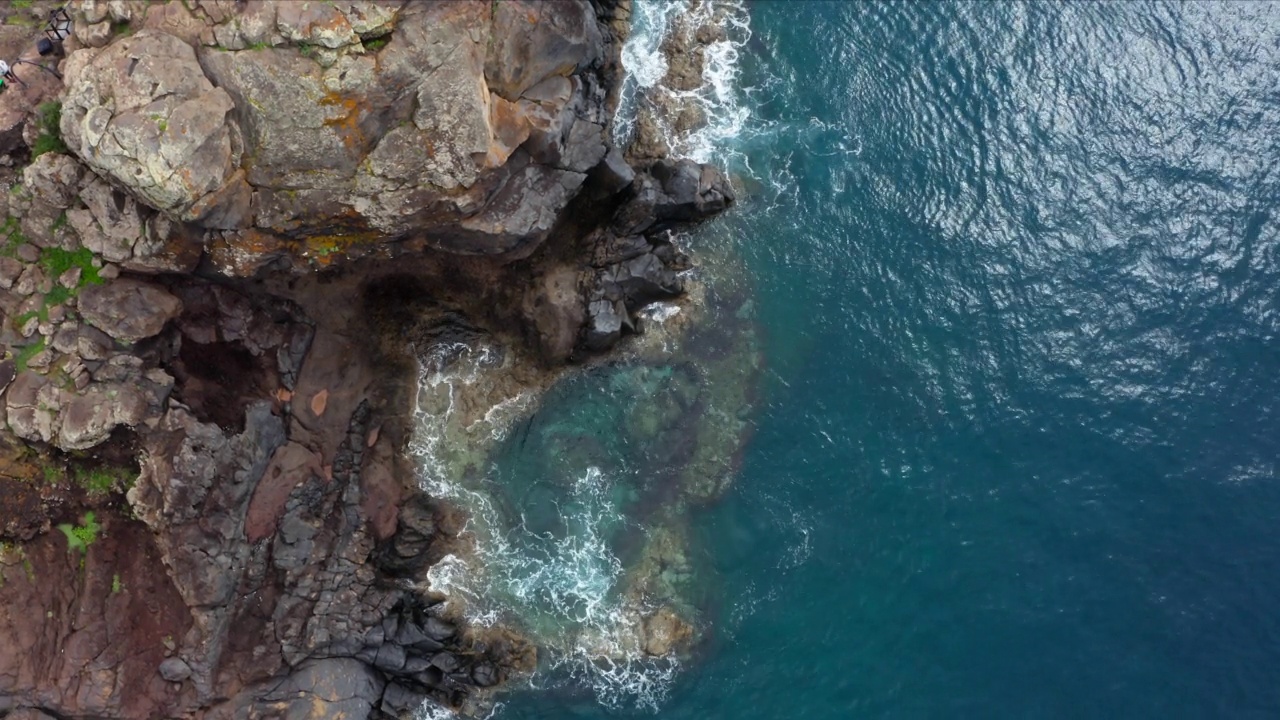 4K镜头的大西洋宁静的海浪冲刷Sao Lourenco海湾悬崖-岬角的东端火山马德拉岛，葡萄牙。视频素材