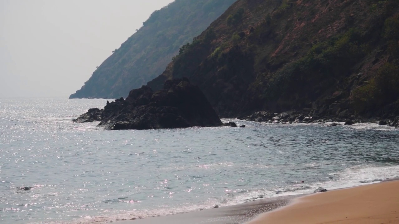 中午，热带岛屿海滩上的海浪。在印度果阿的Kakolem海滩，海浪拍打着海岸。自然热带岛屿背景。海浪拍打着海岸。视频素材