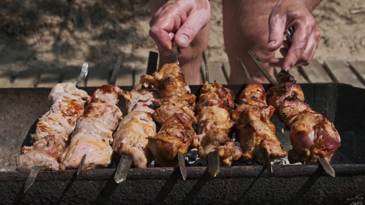 夏日户外用金属串烹制美味羊肉串的过程视频素材