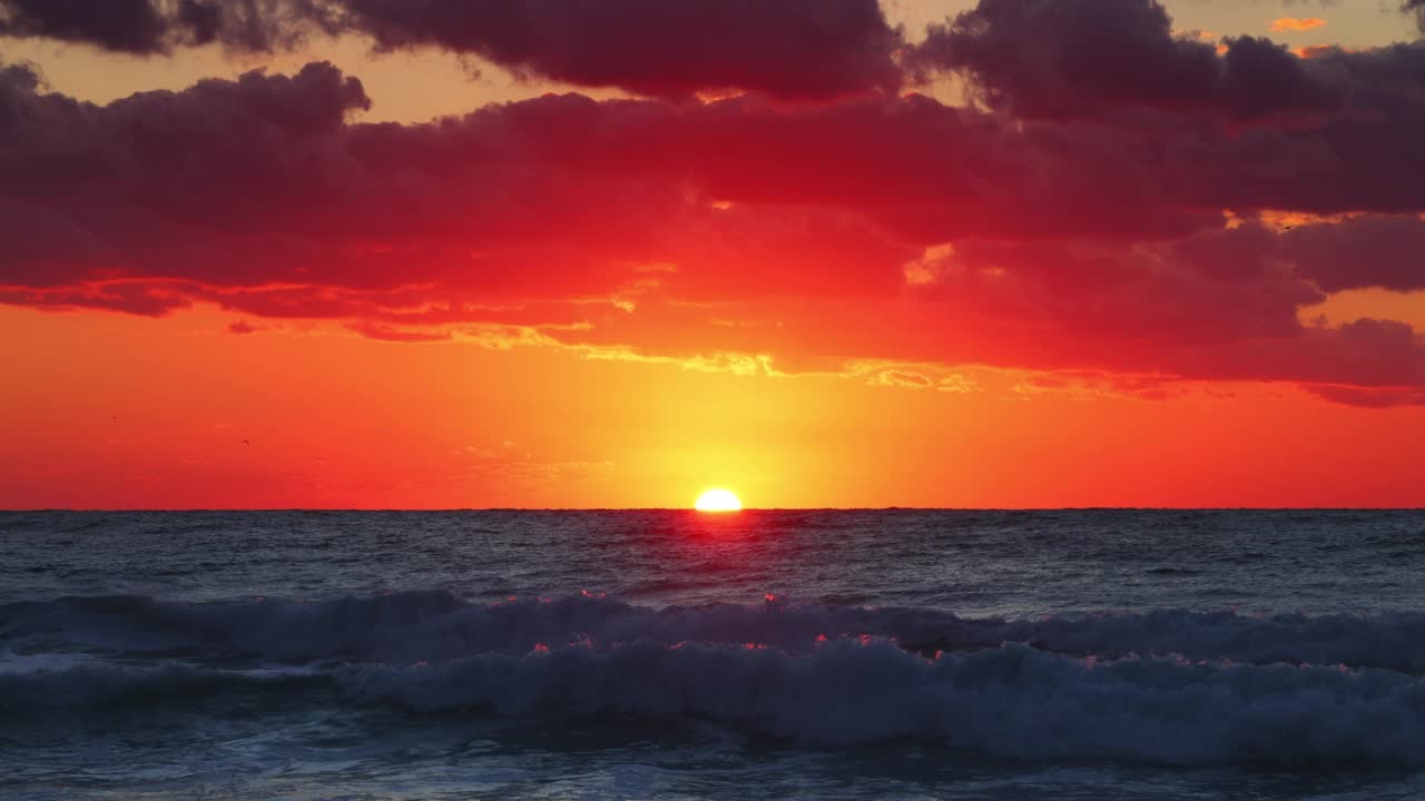 风景优美的海洋海滩日出与燃烧的天空云和海浪视频素材