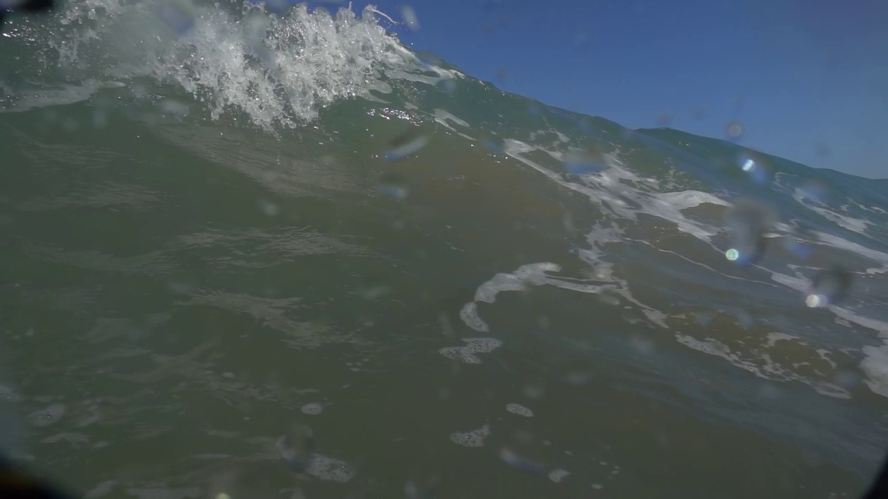 相机浸在水里，在快要淹死的大海上。美丽的光线折射在水面的波浪，潜水，浮潜。视频素材