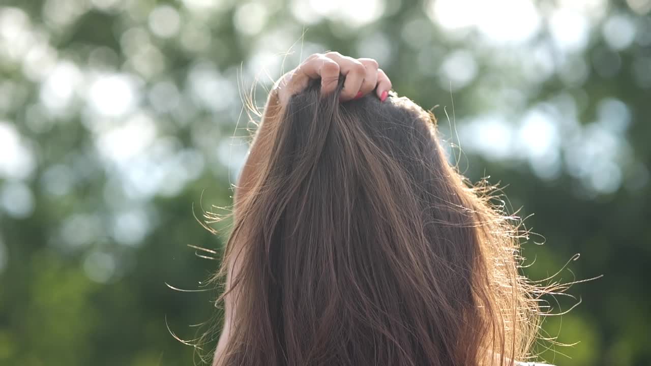 华丽的长发女人走在公园转过头微笑视频素材