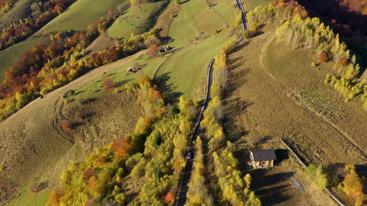 在秋天飞越史诗般的山路。山丘和牧场的鸟瞰图视频素材