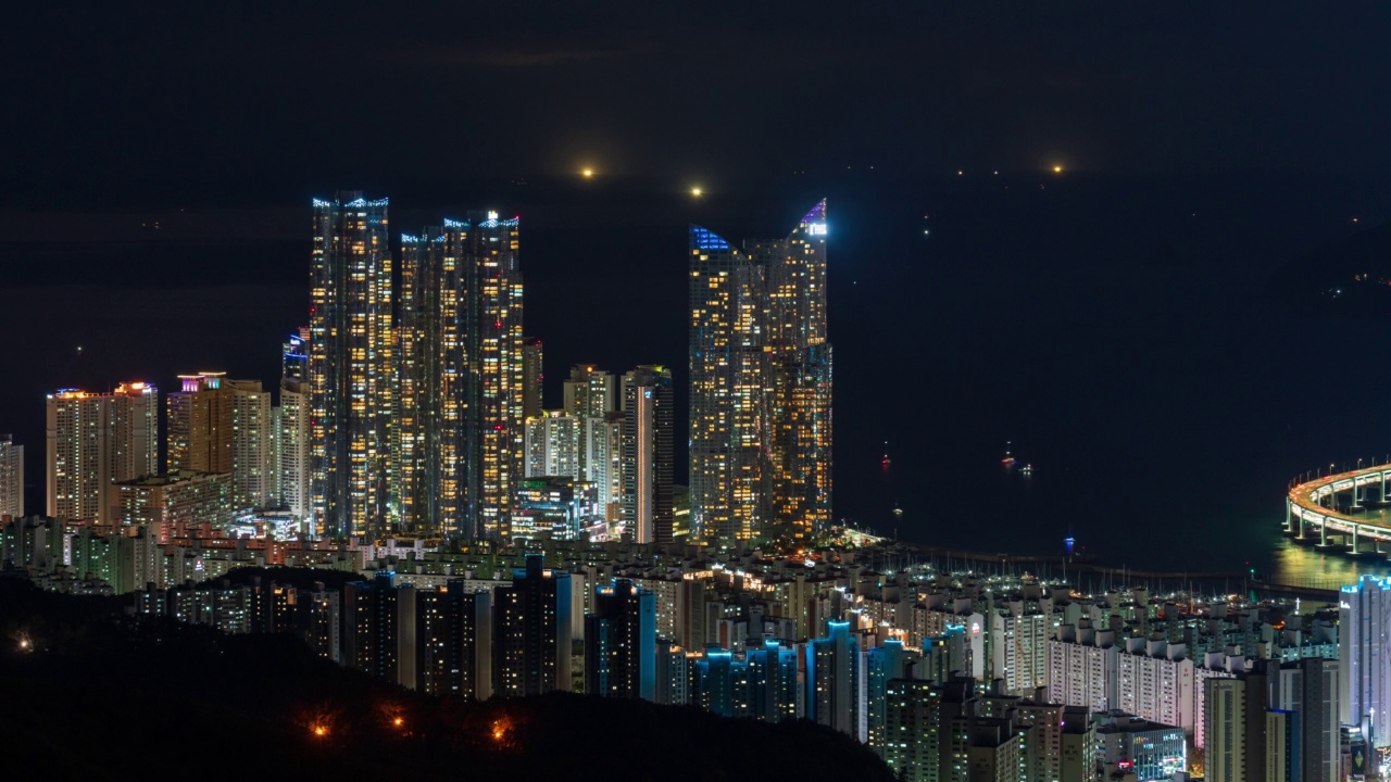 从釜山海云台区长山俯瞰海洋城市周围公寓和摩天大楼的市中心夜景视频素材