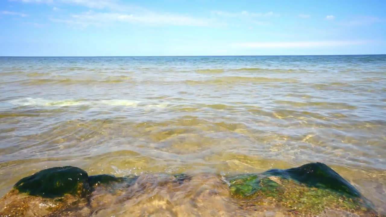 海滩上的岩石表面，飞溅的海浪，波兰波罗的海视频素材