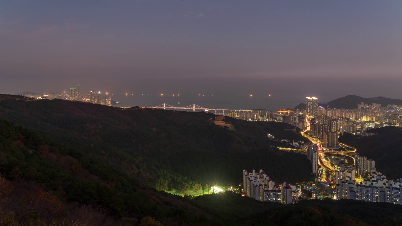 白天和夜晚-从黄陵山观景休息室/釜山，韩国，在海洋城市和广达大桥附近的市中心地区的日落视频素材