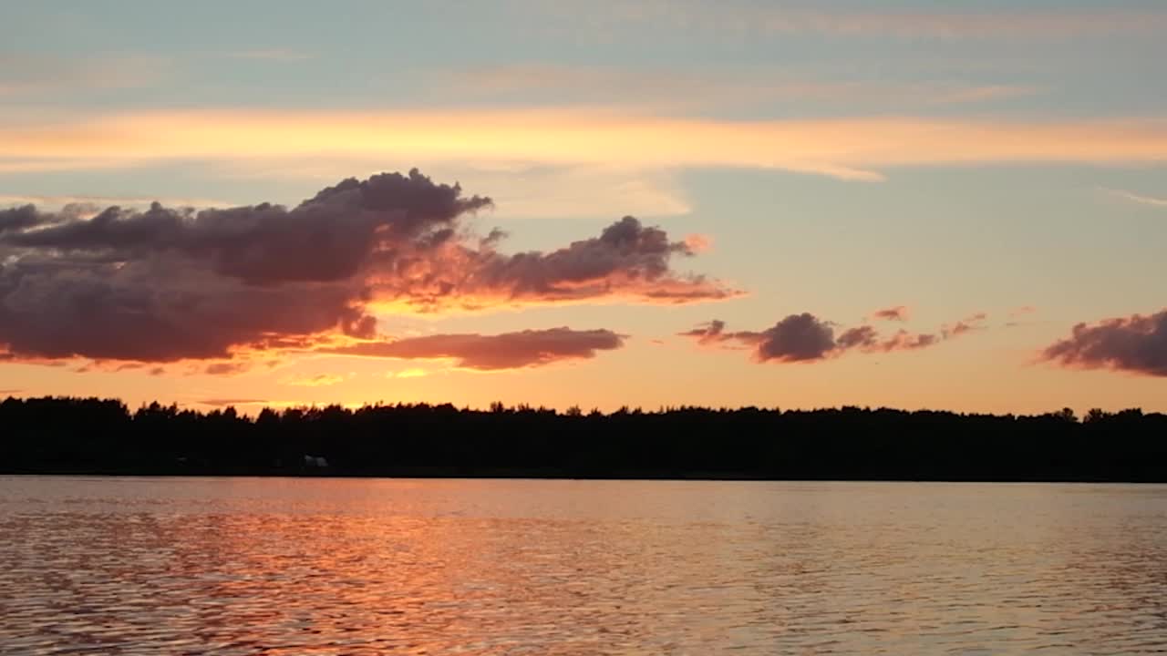 夕阳的余晖映衬着云彩，映衬着河面上的波浪视频素材