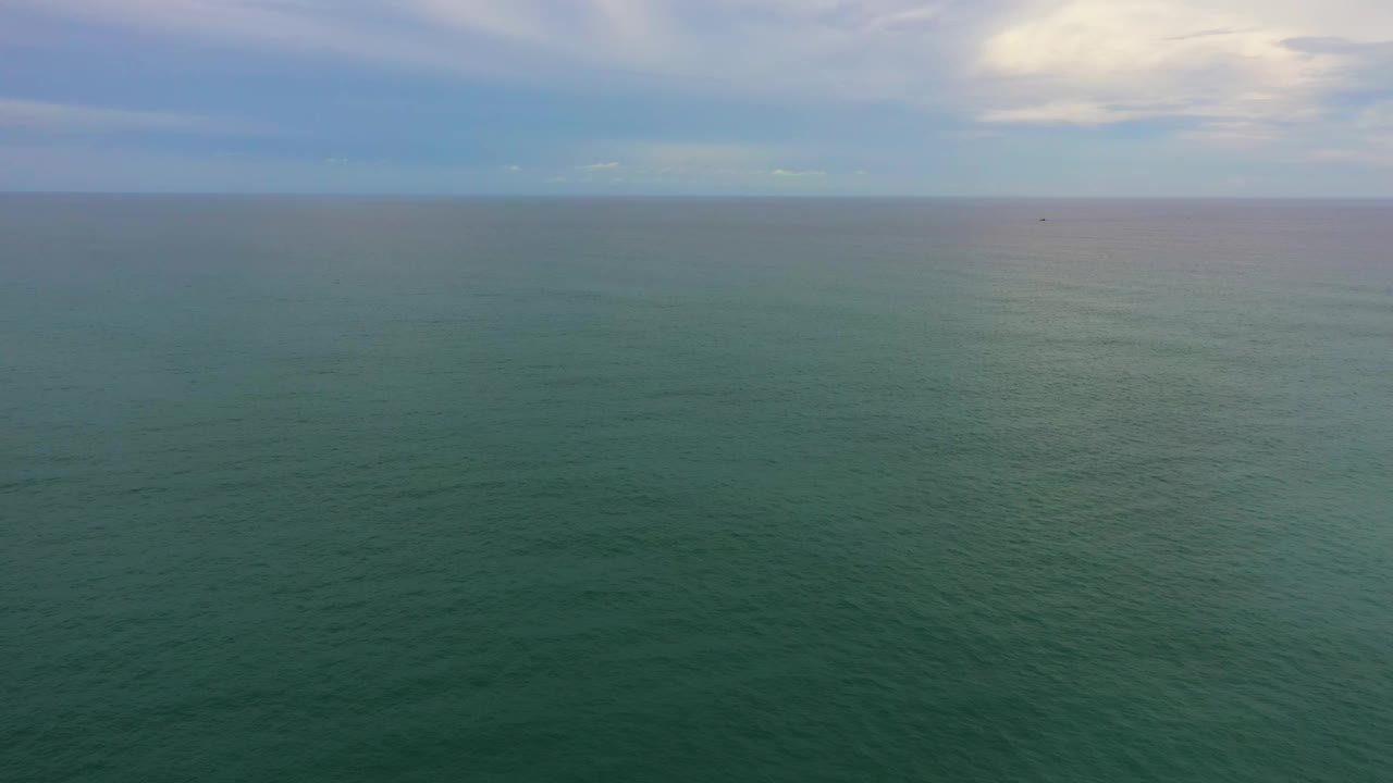 蓝色的海水和波浪映衬着天空。视频素材