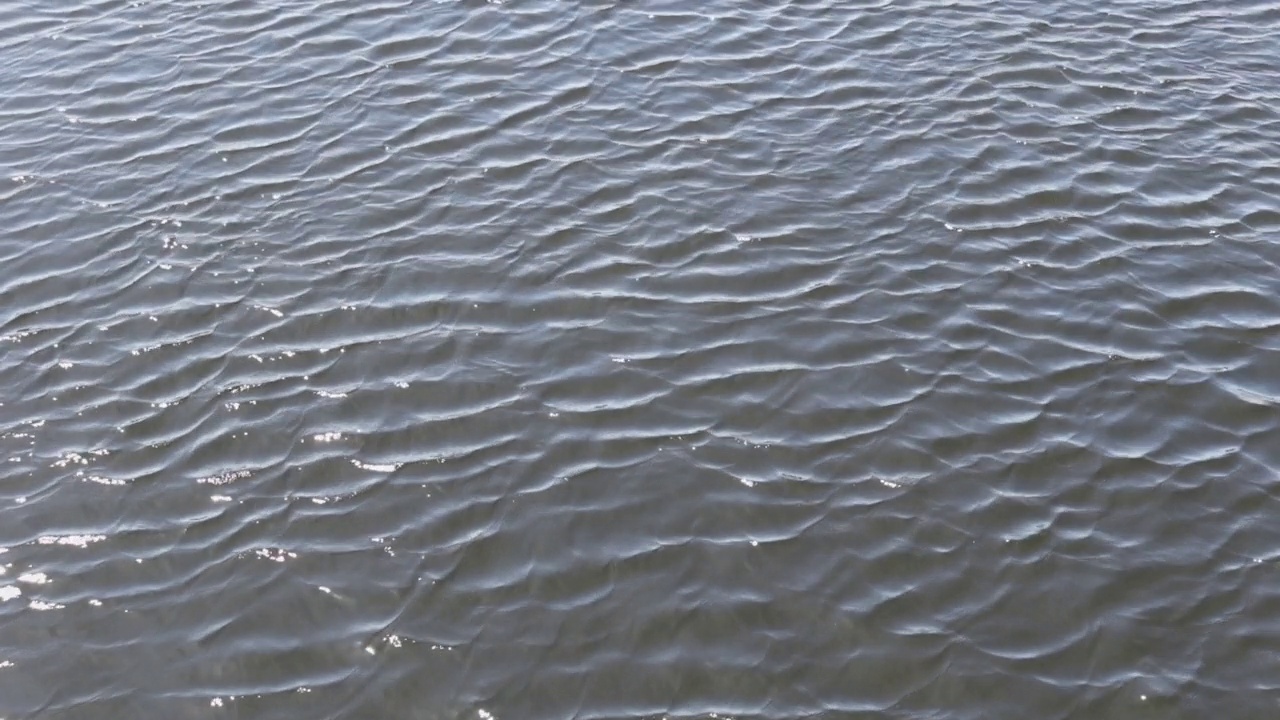 河水平静的灰色波浪在移动。水波背景，4k视频。视频素材