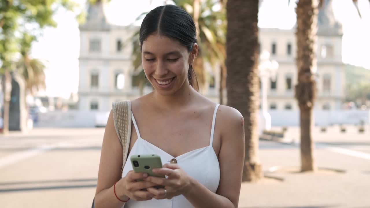 一名西班牙妇女走在街上用手机视频素材