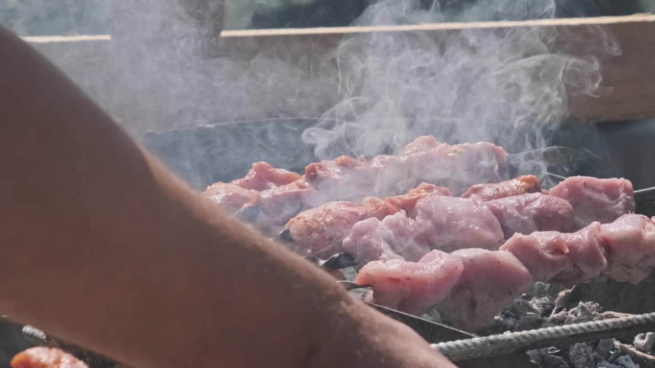 夏日户外用金属串烹制美味羊肉串的过程视频素材