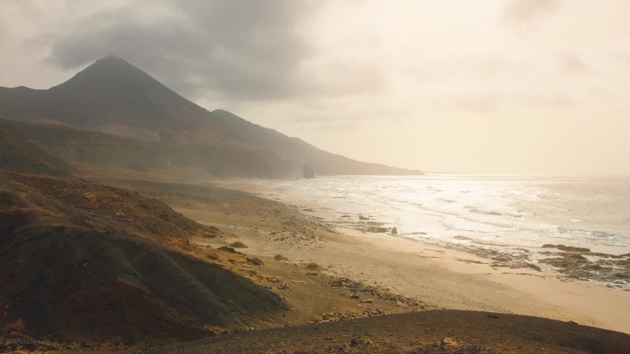 Cofete海滩有着无尽的地平线和黄沙上的痕迹。背景是火山和大西洋。富埃特文图拉，加那利群岛，西班牙视频素材