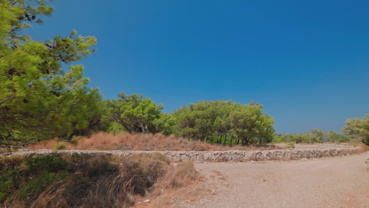 美丽的自然景观与岩石公路在矮山松树之间的山脉。希腊。视频素材