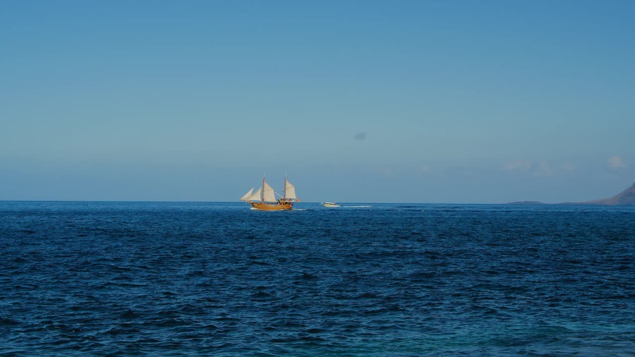 在特内里费岛风浪中驾驶游艇。迷人的海景。孤独的帆船和野猪在阳光下赛跑。宁静的水景和交通。视频素材