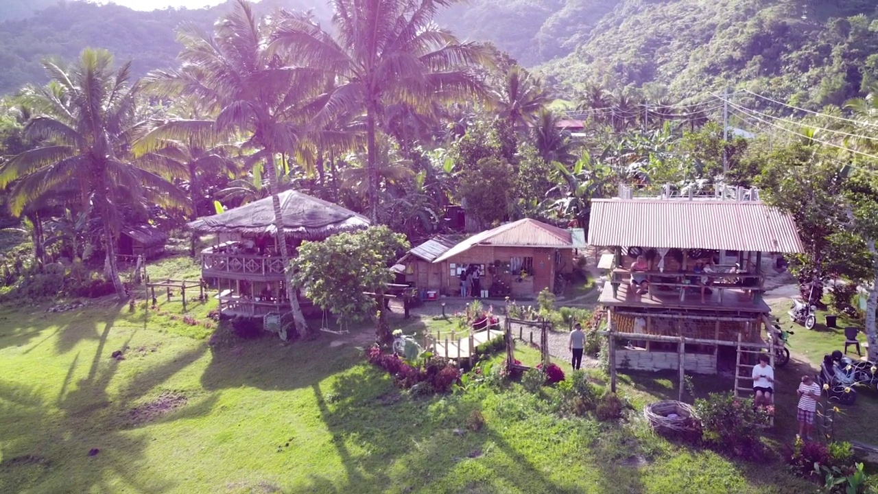 没有一个大的自然社区居住的建筑在一个遗留的地方。附近有一条道路。这架无人机在菲律宾一个丛林村庄的热带地区飞行。在山的后面。视频素材