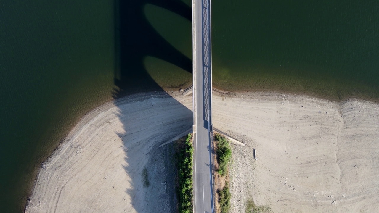 横跨蓝色湖泊的桥上的道路，车辆可以从一个岸到另一个岸。视频素材